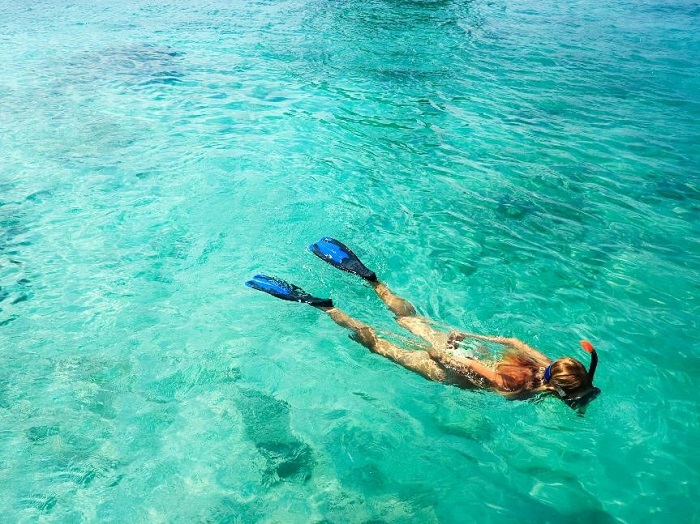woman snorkeling in torquoise water